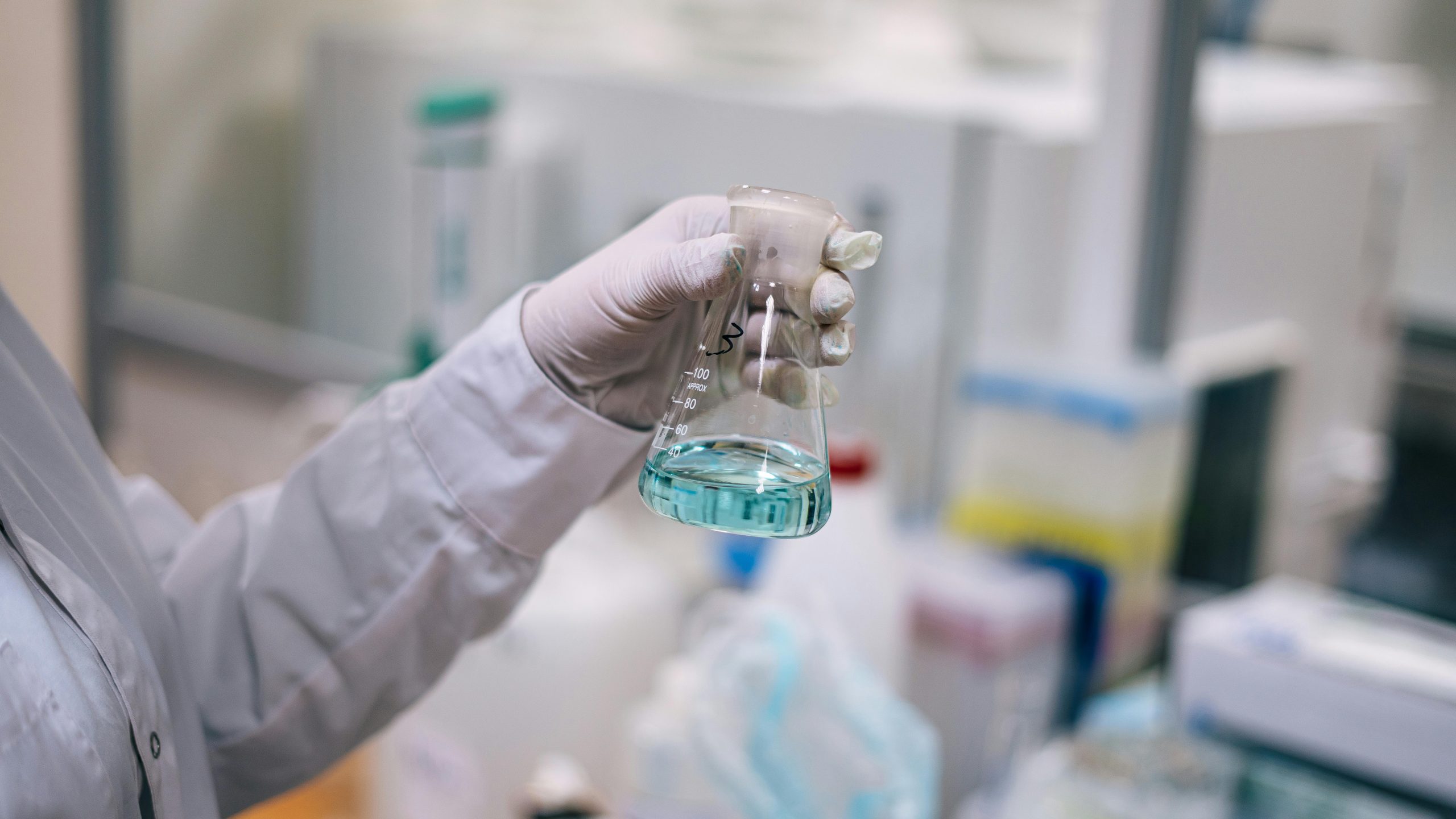 Laboratory scientist holding conical flask